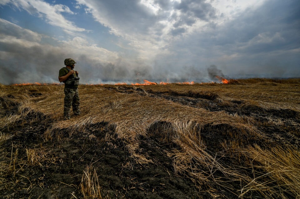 file photo: a ukrainian serviceman stands on a burning wheat field near a frontline on a border between zaporizhzhia and donetsk regions