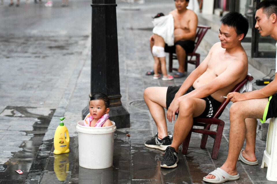 child takes bath in a bucket amid a heatwave warning in huayuan county