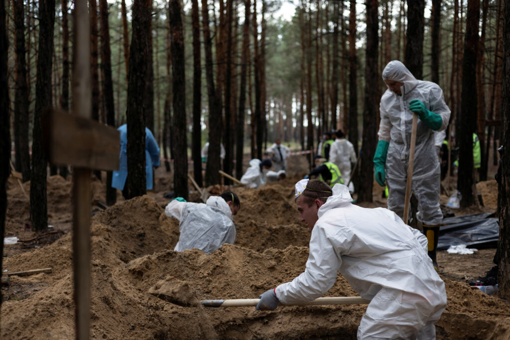 experts work at a forest grave site during an exhumation in izium
