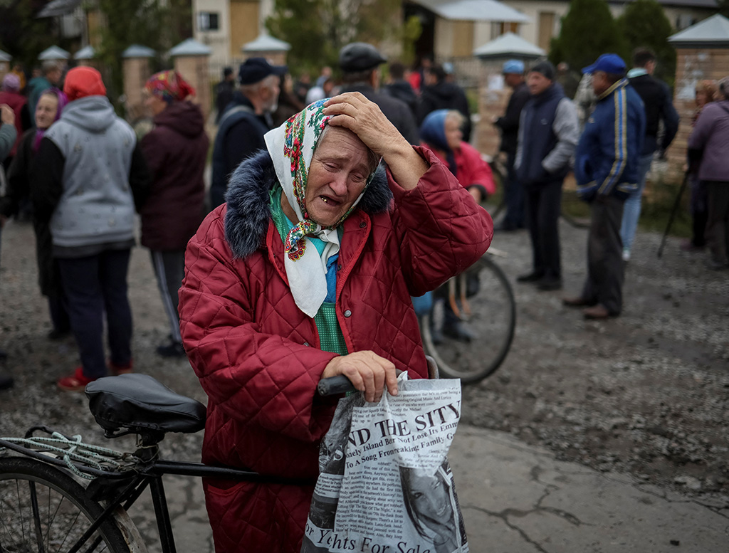local residents wait for a car distributing humanitarian aid in the town of balakliia