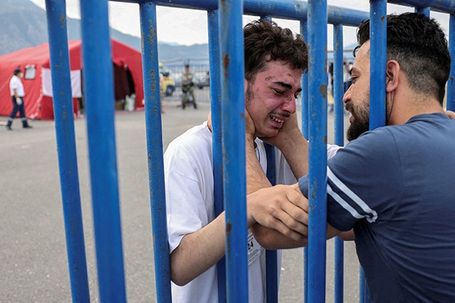 cover Emotional reunion amid despair as Greece searches for shipwreck survivors