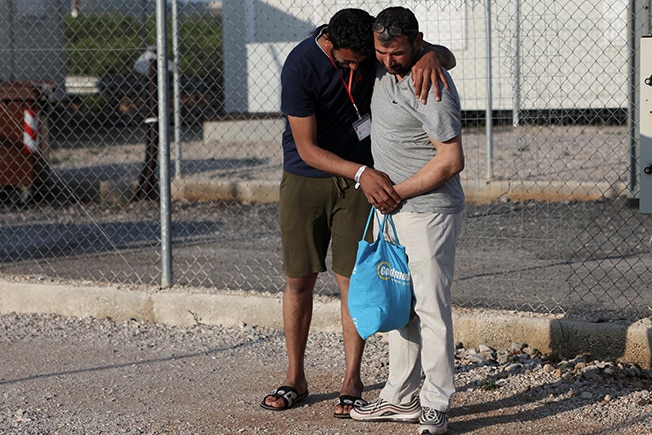 image With scores missing from shipwreck, families flock to Greek migrant camp