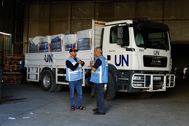 workers sort aid to be distributed to palestinians, at a united nations run facility, in khan younis