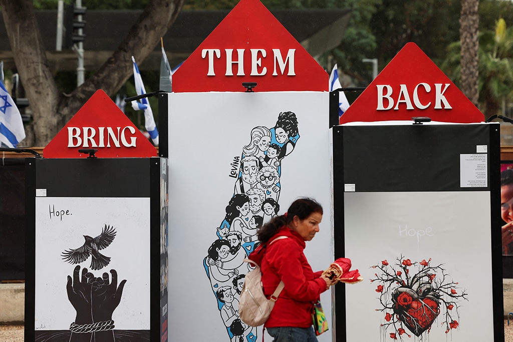 woman walks past an art installation aimed to draw awareness to the people held hostage by the palestinian islamist group hamas