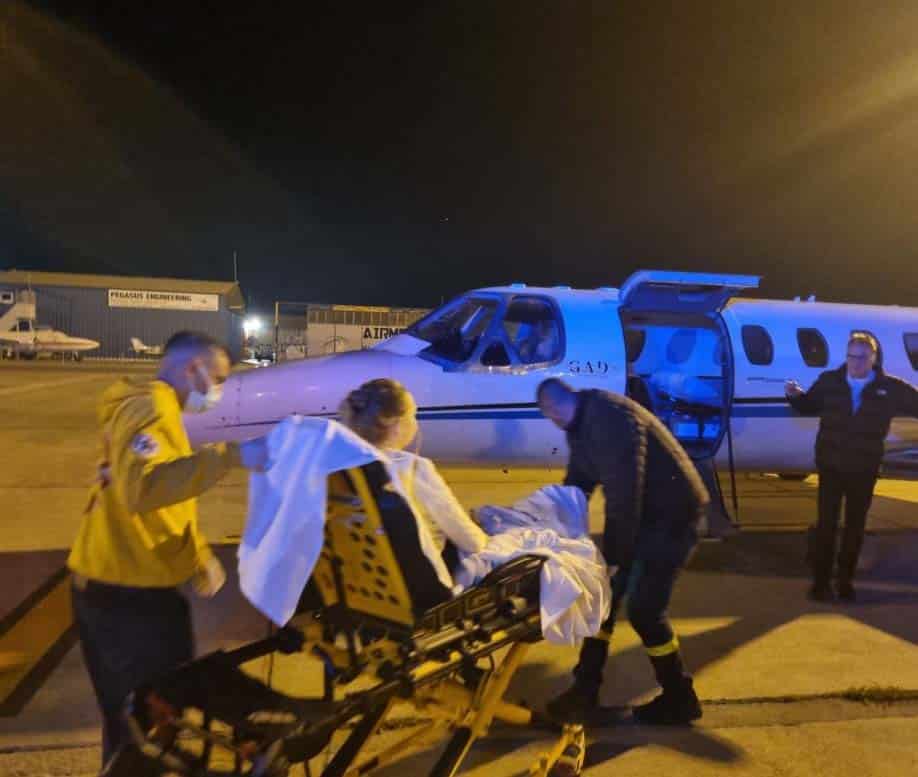 feature rony baiba being transported onto the ambulance plane