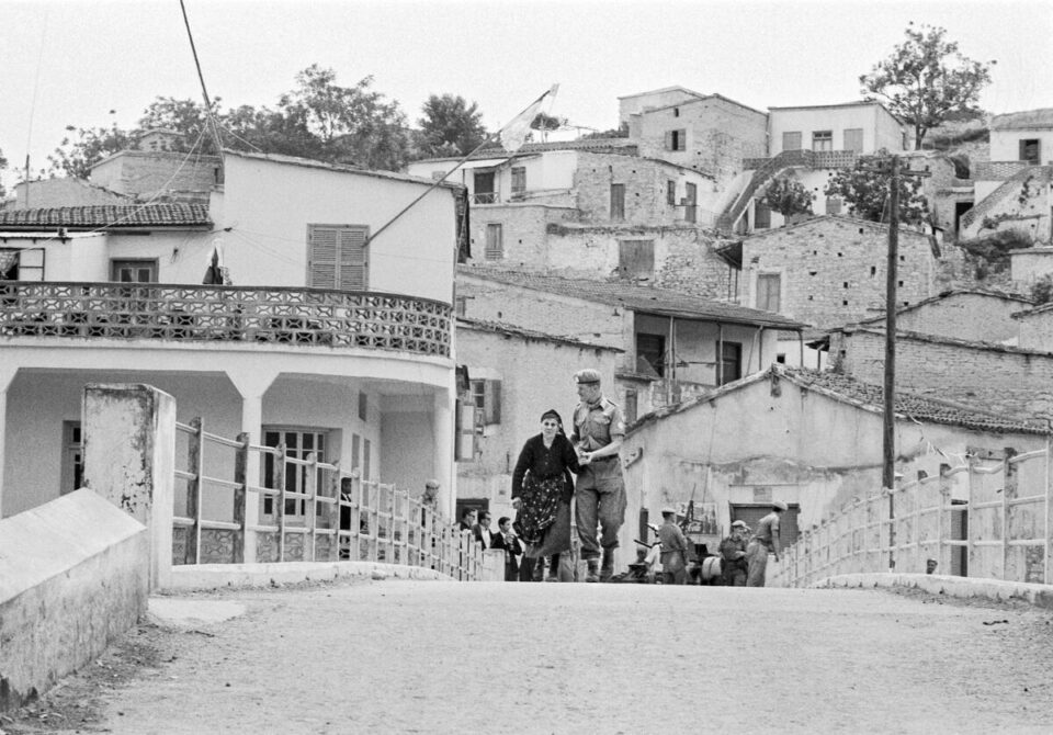 A peacekeeper escorts an elderly Greek Cypriot woman, across the bridge from the Turkish sector to the Greek sector of Ayios Theodoros in 1964