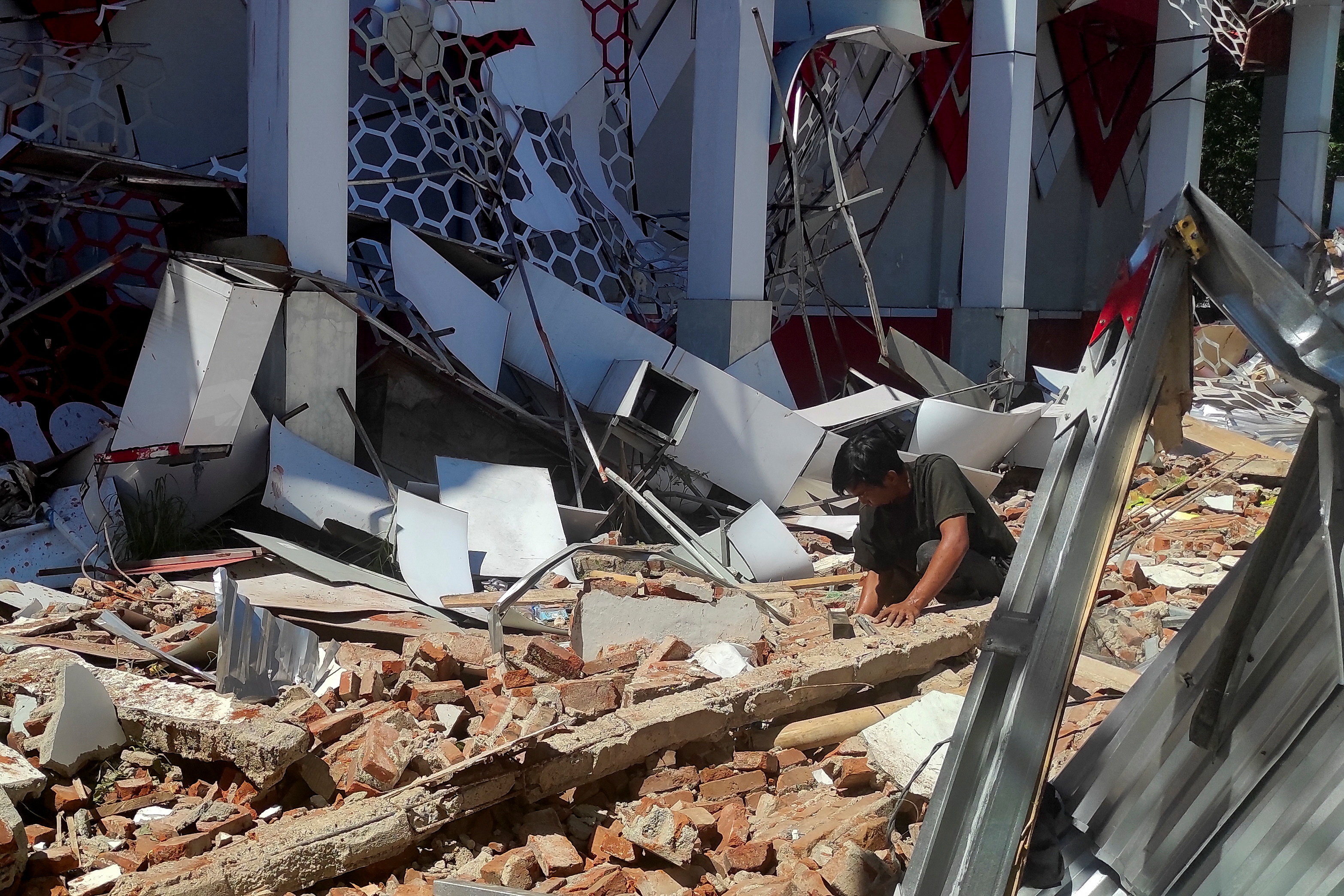 cover Indonesia earthquake damages buildings, but tsunami alerts have been lifted