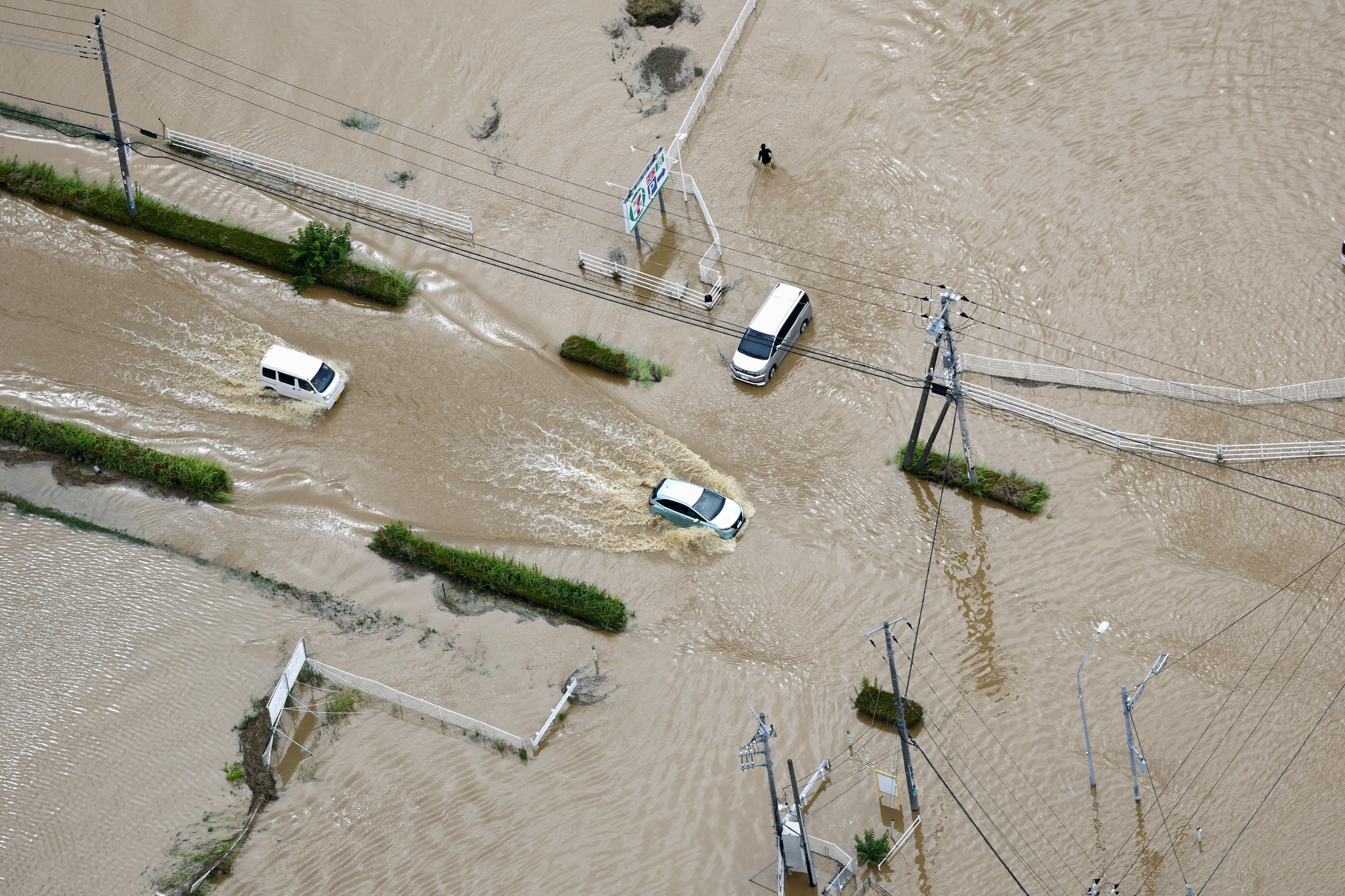 cover Thousands stranded at Tokyo&#8217;s Narita airport after record rain kills four